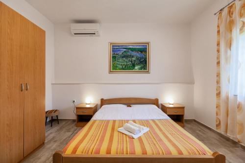 1 dormitorio con 1 cama con 2 mesitas de noche y 2 mesas en Apartment Ema, en Premantura