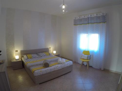 a bedroom with a bed and a window and a chair at Casa Talita in Caprino Veronese