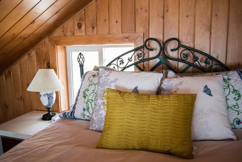 a bedroom with a bed with a metal head board at Maison sur la plage TERRE-MÈRE in Grenville-sur-la-Rouge