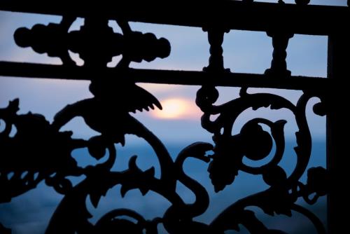 a silhouette of a fence with a sunset in the background at Paradosiako Saratsi - Traditional Guest House in Volos