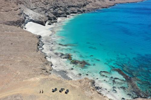 a group of people standing on a beach next to the ocean at bed & breakfast Regina in Tarrafal