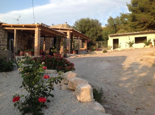 a house with flowers in front of a building at Vento Del Sud in Chiaramonte Gulfi