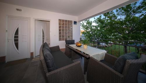 a patio with a table and chairs on a balcony at Apartman Karla in Solin