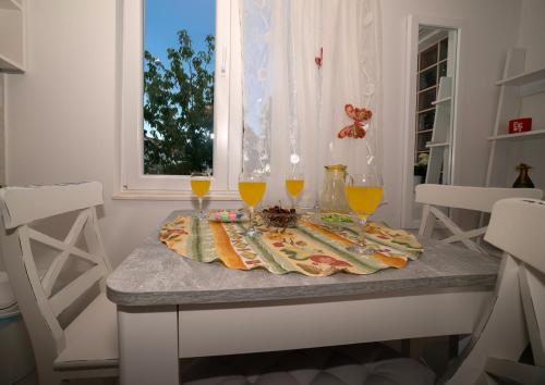 a table with three glasses of orange juice on it at Apartman Karla in Solin