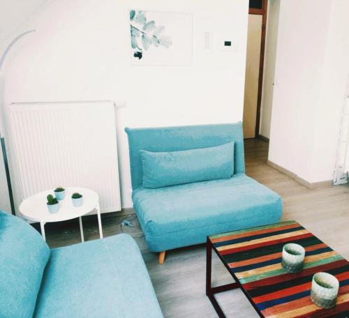 a living room with a blue couch and a table at Greenfee vakantieappartement in De Haan