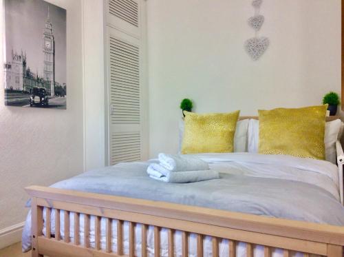 um quarto com uma cama com almofadas amarelas em Station House em Didcot