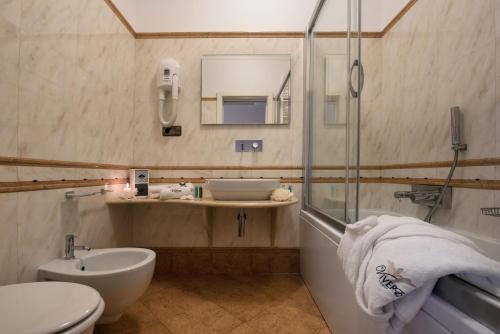 e bagno con lavandino, servizi igienici e doccia. di ViverE' Resort a Presicce