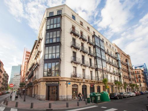 Un alto edificio bianco in una strada di città di Cosy Room - Guggen º PARKING FREE a Bilbao