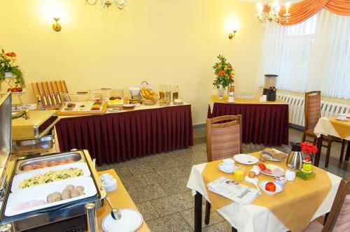 Hotel Stadt Löbau في لوباو: مطعم بطاولتين عليها طعام