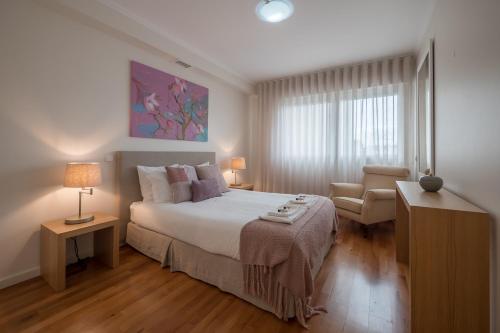 a bedroom with a large bed and a chair at Saldanha - 74307AL in Lisbon