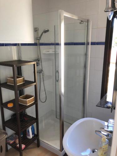 La salle de bains est pourvue d'une douche et d'un lavabo blanc. dans l'établissement résidence arimarina, à Lumio