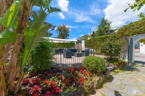 a garden with flowers and a fence at Villa Fortuna Holiday Resort in Ischia