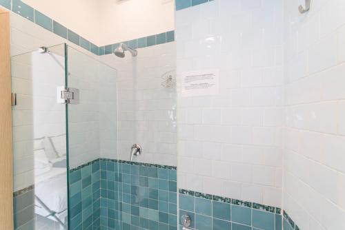a bathroom with a shower with blue and white tiles at Villa Fortuna Holiday Resort in Ischia