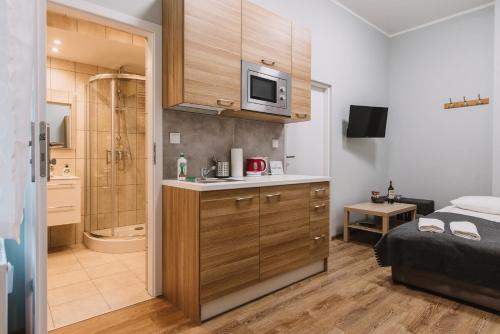 a bathroom with a bed and a shower in a room at Sopot Host Studio in Sopot