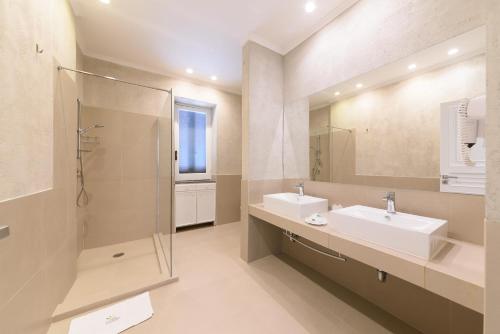 a bathroom with two sinks and a shower and a mirror at Villa Fortuna Holiday Resort in Ischia