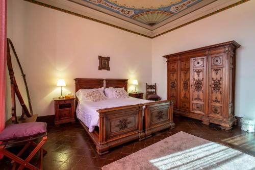 una camera con un letto e un grande armadio in legno di Agriturismo Villa Cavallini a Camaiore