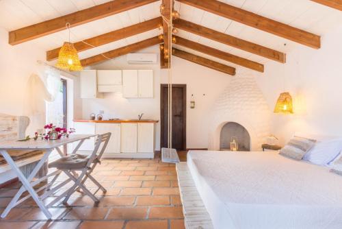 una cucina e un soggiorno con letto e tavolo di Deppy Cottage a Porto Columbu - Perdʼe Sali