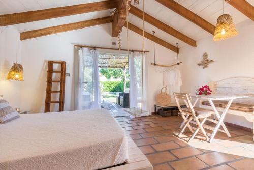 a bedroom with a bed and a table and chairs at Deppy Cottage in Porto Columbu - Perdʼe Sali
