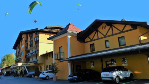 a building with two cars parked in a parking lot at Vital & Sporthotel Brixen in Brixen im Thale