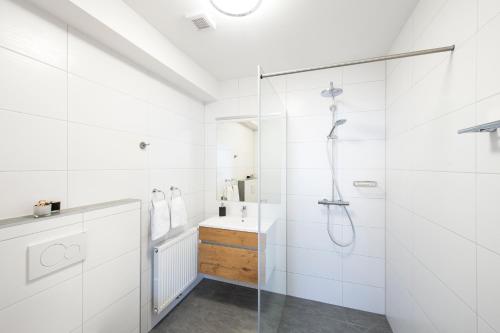 biała łazienka z prysznicem i umywalką w obiekcie Gasthof Eckberg w mieście Unzmarkt