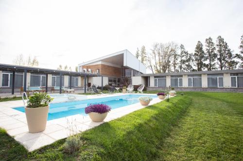 a house with a swimming pool in a yard at Herradura Hotel Suites in Neuquén