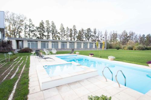 a swimming pool in the backyard of a house at Herradura Hotel Suites in Neuquén