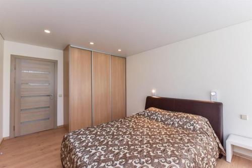 ein Schlafzimmer mit einem großen Bett und einem Kleiderschrank in der Unterkunft Crystal Apartment in Druskininkai