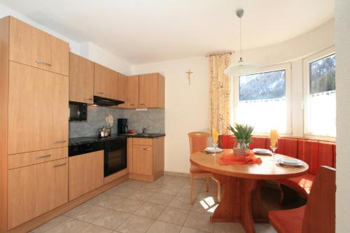 a kitchen with a wooden table and a dining room at Adlerhof in Sankt Leonhard im Pitztal