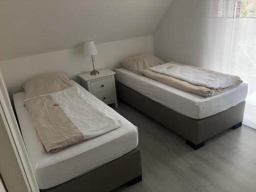 2 camas en un dormitorio con lámpara en una mesita de noche en Ferienhaus am Emmerbach, en Ascheberg
