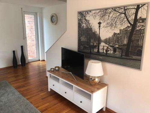 a living room with a flat screen tv on a cabinet at Ferienhaus am Emmerbach in Ascheberg
