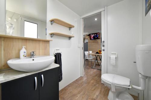 a bathroom with a white sink and a toilet at Mobile Home MeeLi in Biograd na Moru