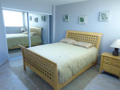 a bedroom with a bed and a mirror at Beachfront Calafia Condos in Rosarito