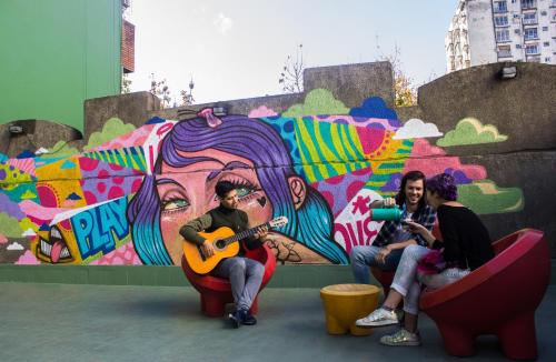 a group of people sitting in front of a wall at Play Hostel Arcos in Buenos Aires
