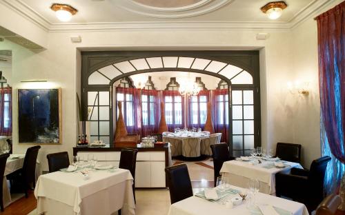 a dining room with two tables with white tablecloths at Hotel Sant Roc in Solsona
