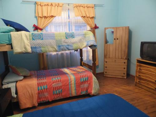a bedroom with two bunk beds and a television at Hostal Tricontinental in Valparaíso