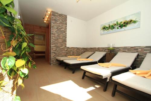 a waiting area with tables and benches in a room at Adlerhof in Sankt Leonhard im Pitztal
