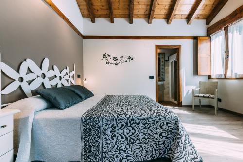 1 dormitorio con 1 cama con edredón blanco y negro en Casa Rural Monte Perdido, en Sarvisé