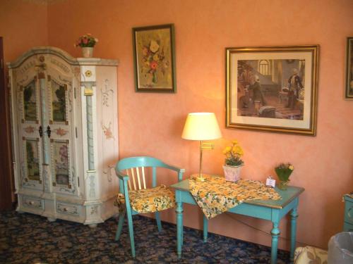 a room with a desk and a table and chairs at Hotel Barmstedter Hof in Barmstedt