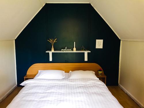 a bedroom with a large bed with a blue wall at Camping Ursulet Durau in Ceahlău