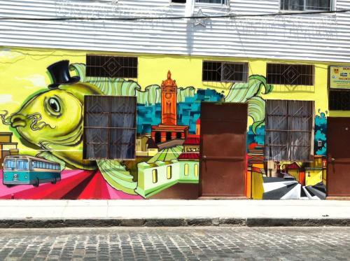 ein Wandbild an der Seite eines Gebäudes in der Unterkunft Hostal Tricontinental in Valparaíso