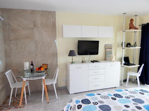 1 dormitorio con cama, mesa y TV en Apartamento Monis Natura en Icod de los Vinos