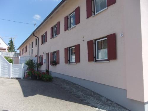 a building with red windows and a white fence at Allgäu Apartment in Memmingen