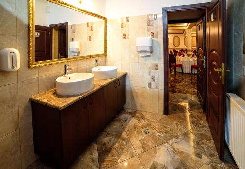 a bathroom with two sinks and a mirror at Equinoxe Royal Reghin in Reghin