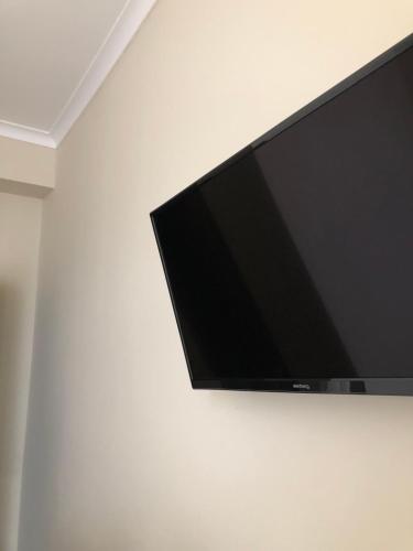 uma televisão de ecrã plano pendurada numa parede branca em El Mundo Apartments em Lviv