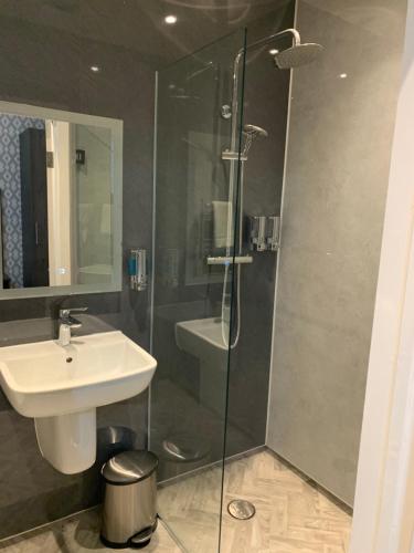a bathroom with a sink and a glass shower at Casuarina Tree in Mitcham
