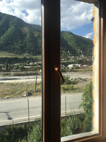 a window with a view of a road and mountains at Apartment Jorjo Mestia in Mestia