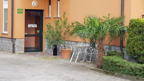 a building with a table and chairs in front of it at La Collina in Casnate con Bernate