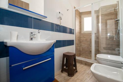 フォンターネ・ビアンケにあるVilla Marika con Piscinaの青と白のバスルーム(洗面台、トイレ付)