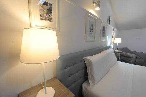 a bedroom with a bed with a lamp and a couch at Aduepassi apartments in Manfredonia