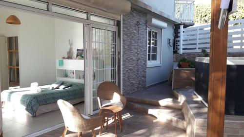 a patio with a bed and chairs in a room at L'Eden des Colibris in Vieux-Habitants
